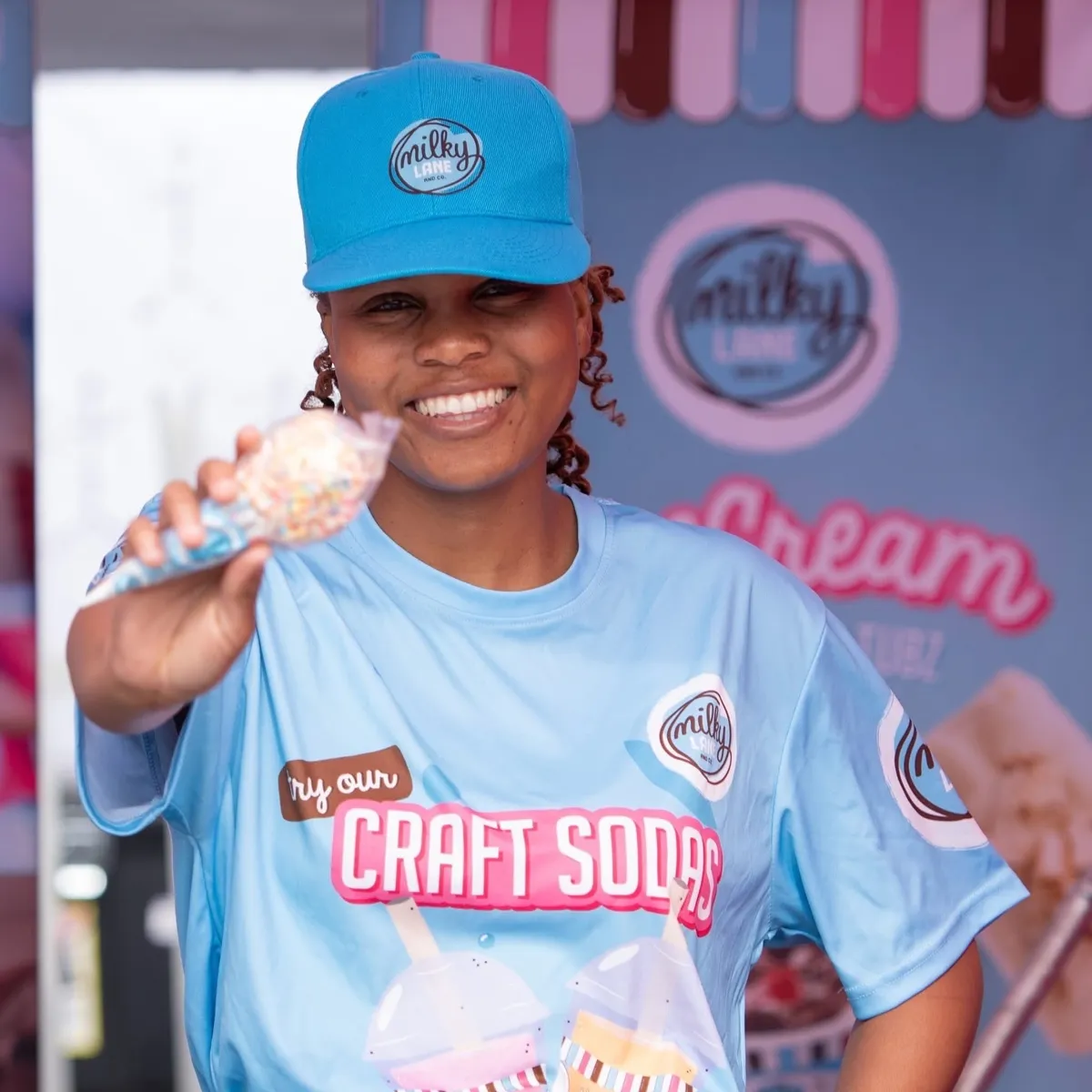 Milky Lane staff member in a branded sublimated T-shirt and cap